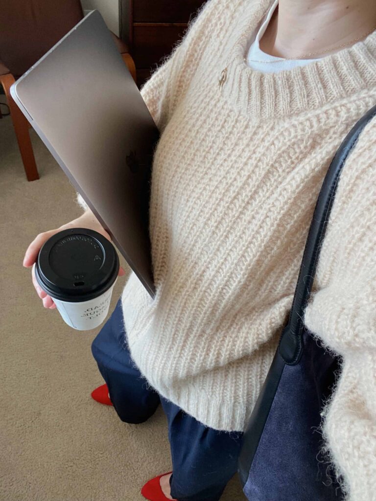 student holding laptop and coffee