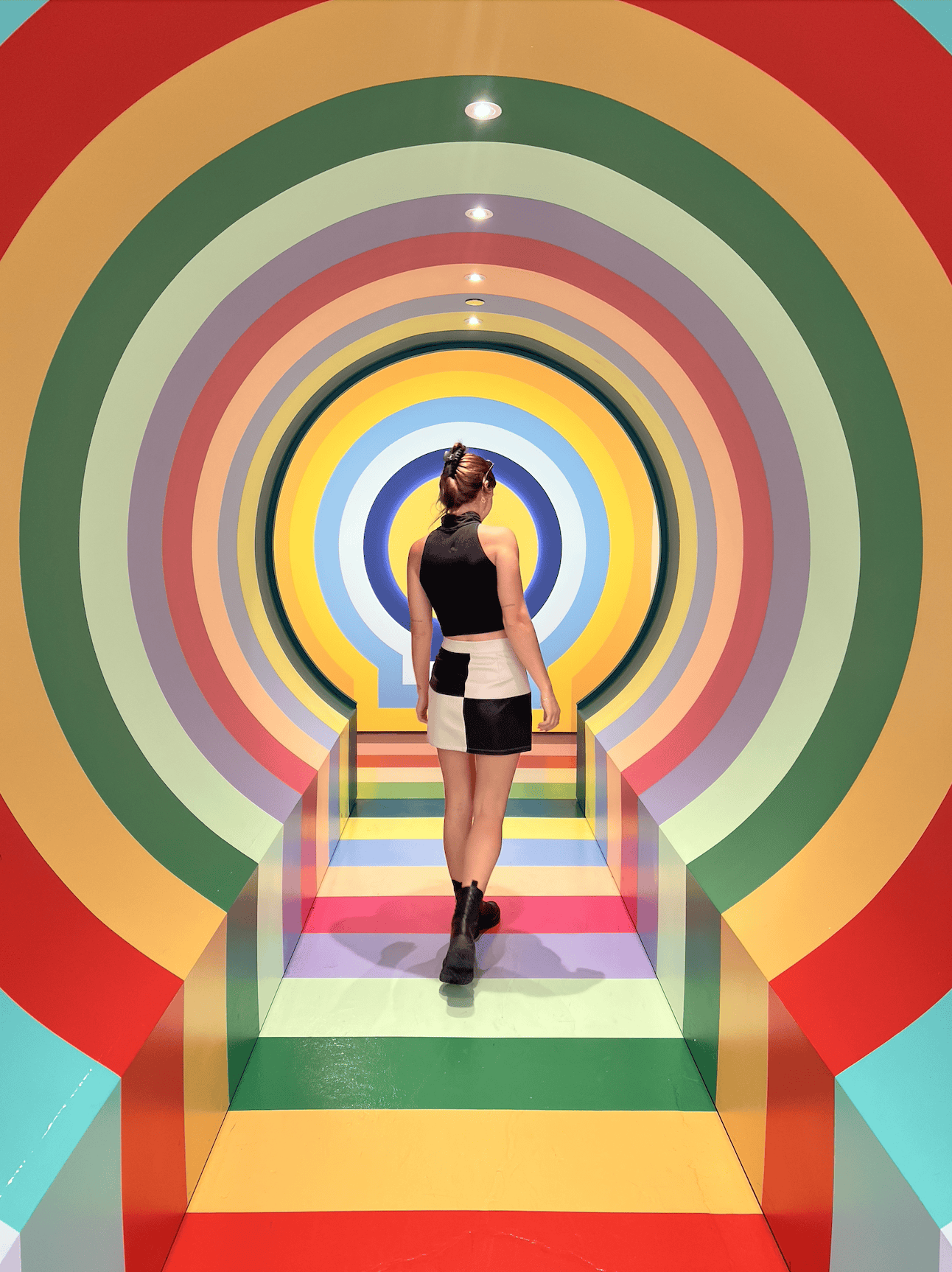 Woman walking down colourful hallway