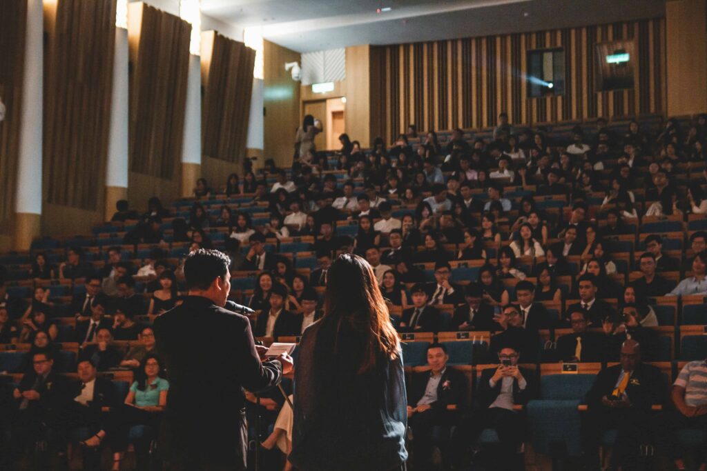 Presenters speaking in front of crowd