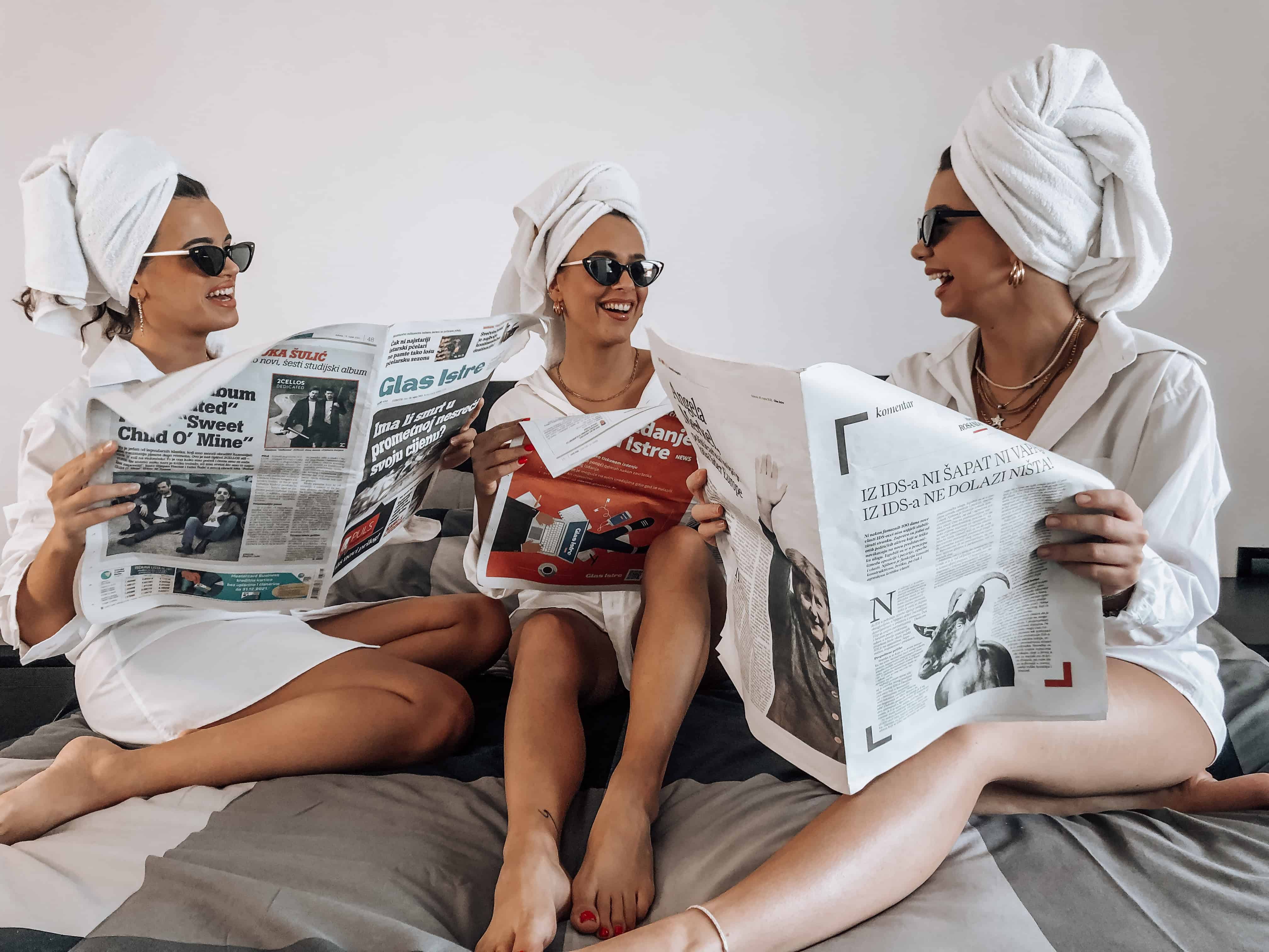 girls reading newspapers